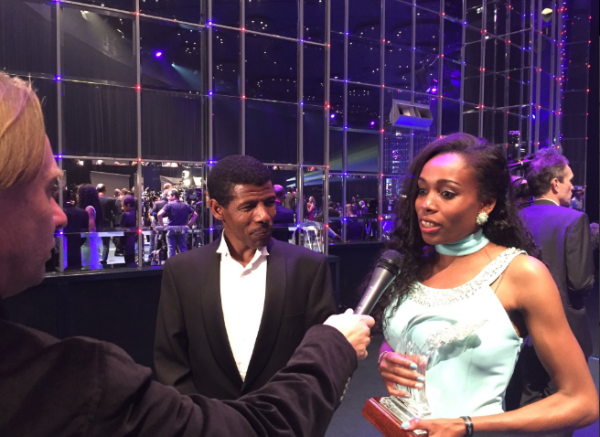 Ayana receiving speaking after receiving her award with fellow Ethiopian and former Olympic champion, Haile Gebrselassie interpreting for her. Photo Credit: @iaaforg 
